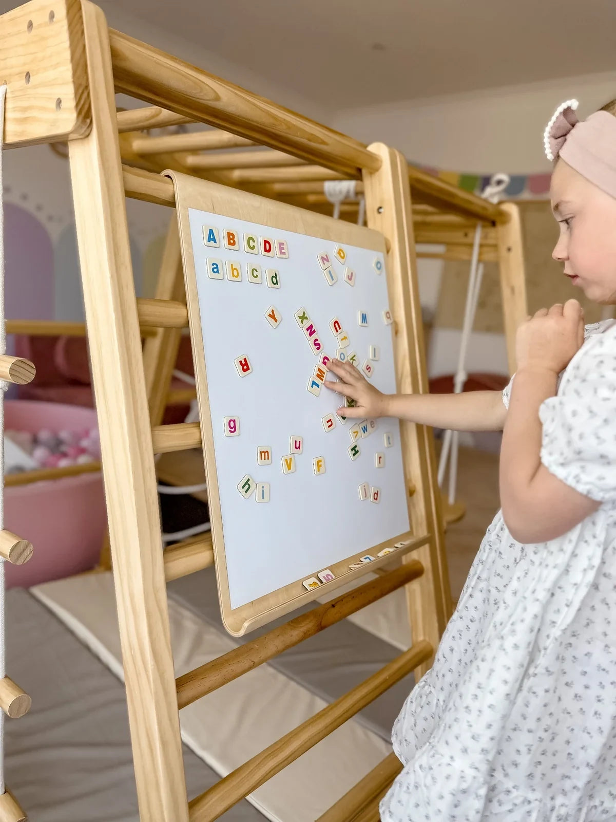 Riababy magnetic board hung at child height on a playhouse