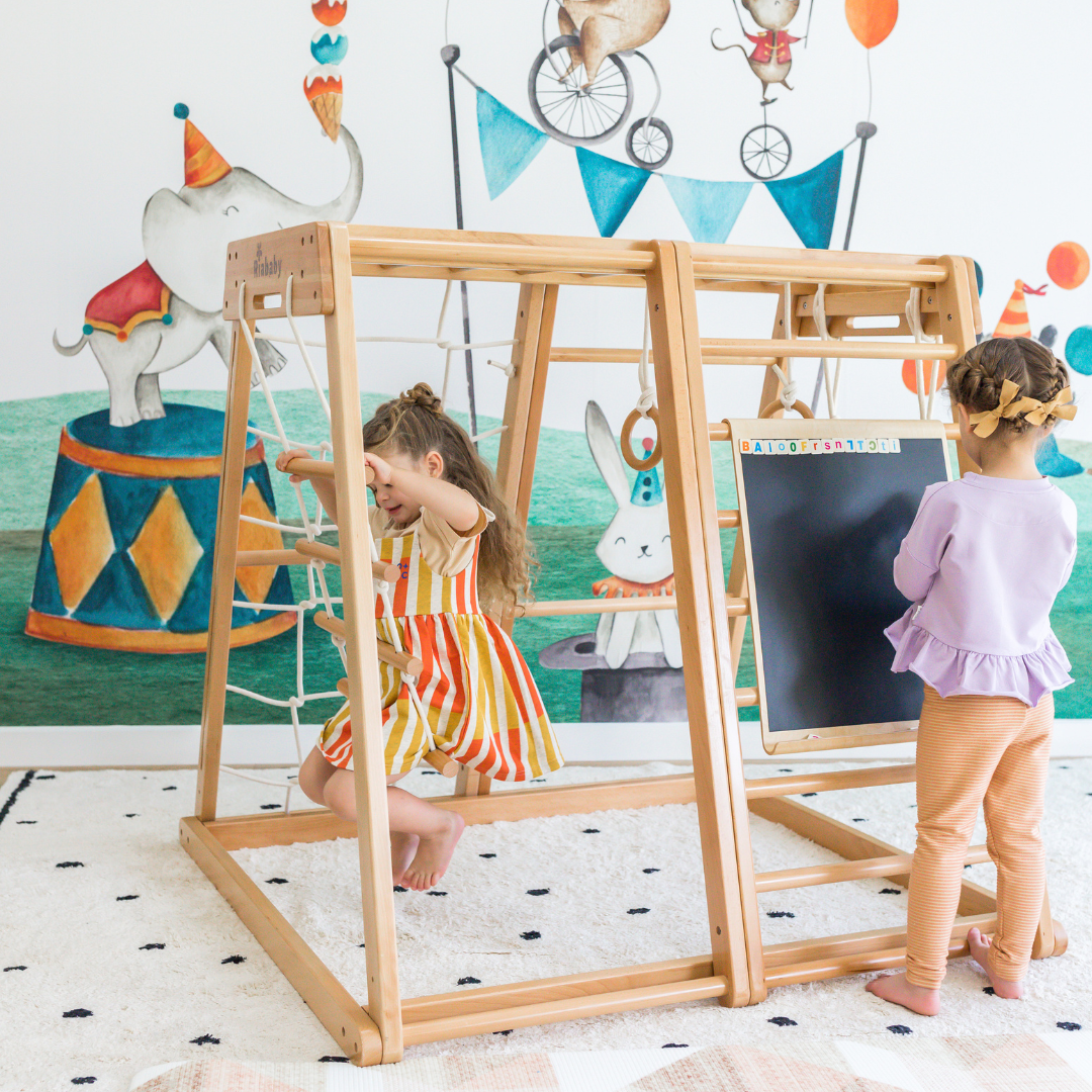 Two children using the black side of the magnetic drawing board on a Kangaroo Playhouse