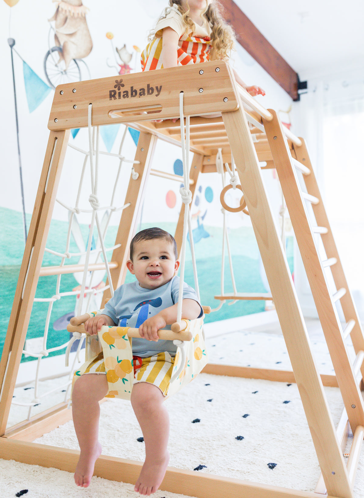 Baby sitting in the Lucky Lemon Riababy baby swing