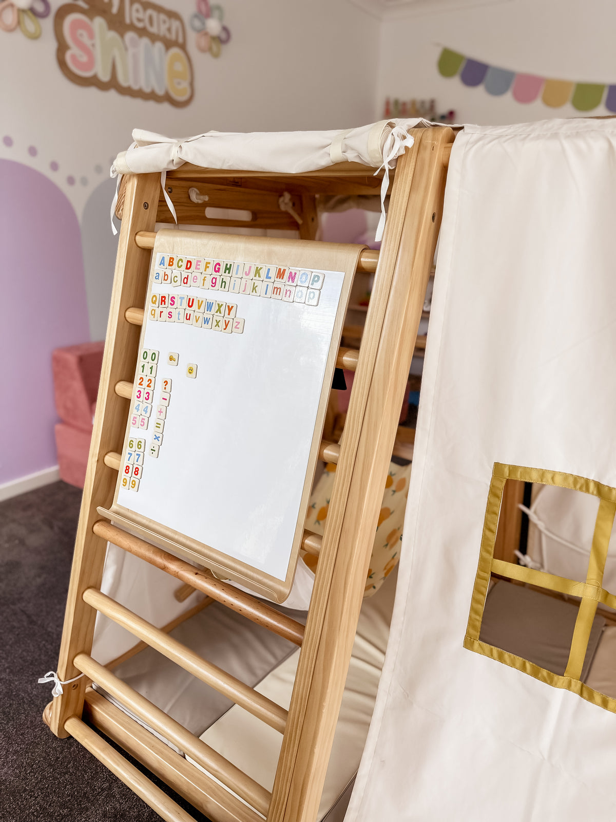 White side of the magnetic drawing board mounted on a Kangaroo Playhouse beside an optional cubby tent