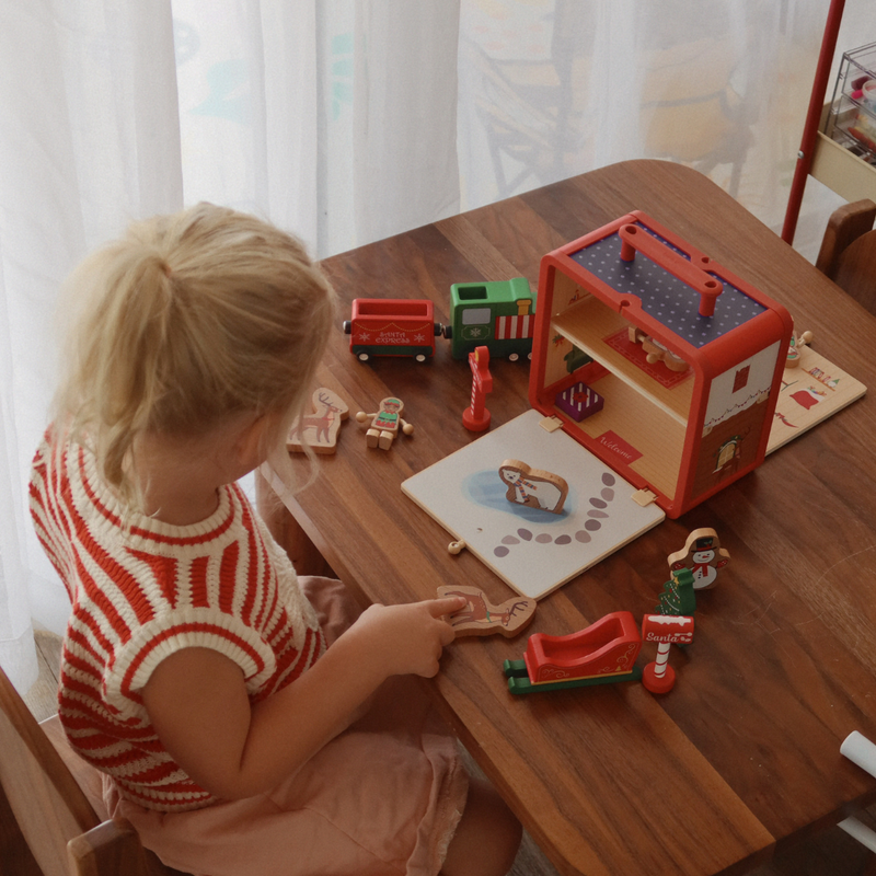 Child playing with the Santa’s Workshop GoBox and wooden Christmas characters at a table