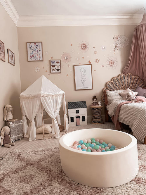 Children's room with a play area featuring a ball pit, canopy, and toys.