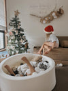 Children playing with Christmas decorations in a living room decorated for the holidays.