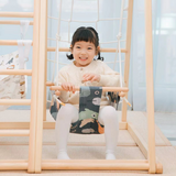 Child sitting in a Happy Bear swing attached to a Kangaroo playhouse