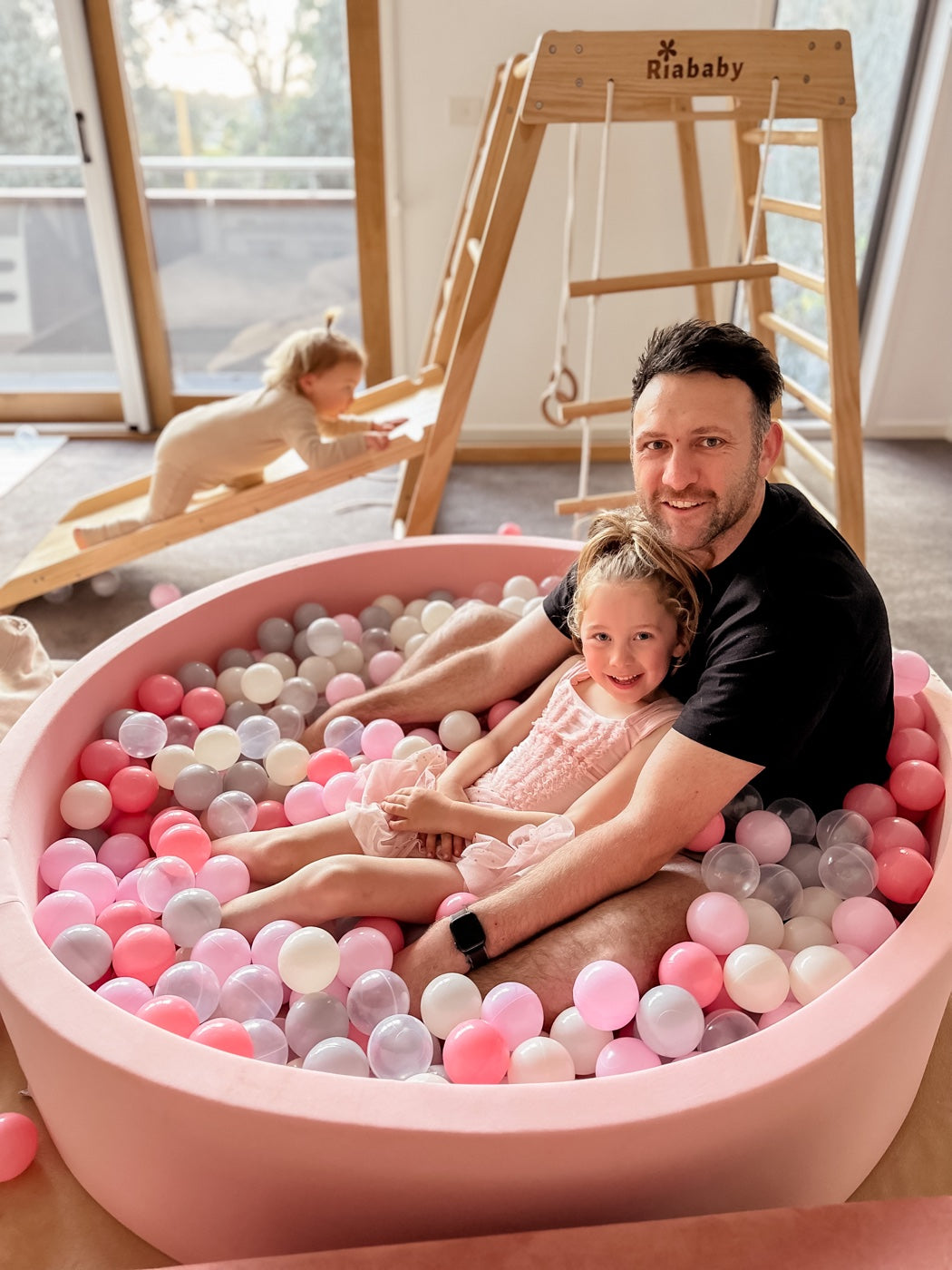 A parent and child in a pink 130cm round ball pit